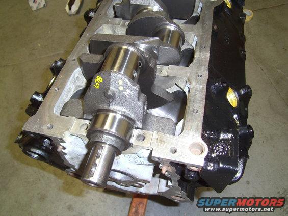 Engine block with crankshaft, showing yellow markings and a water pump pulley shaft