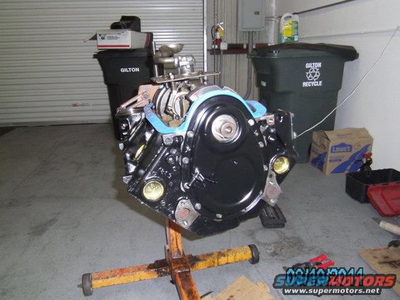 Black engine block on yellow stand, front view