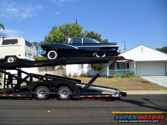 Black 1956 Ford Fairlane on car hauler, white VW van on lower deck