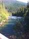 1990 Ford Bronco - A scenic view of a river winding through a forested mountain landscape on a sunny day.