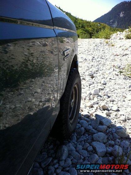 Side view of a dark 1990 Ford Bronco on a rocky mountain road