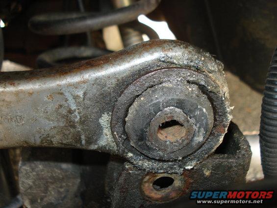 Close-up of a worn rubber suspension bushing on a metal control arm