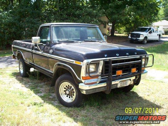 1979 Ford F-250 pickup truck parked on grass with a newer white Ford pickup in the background