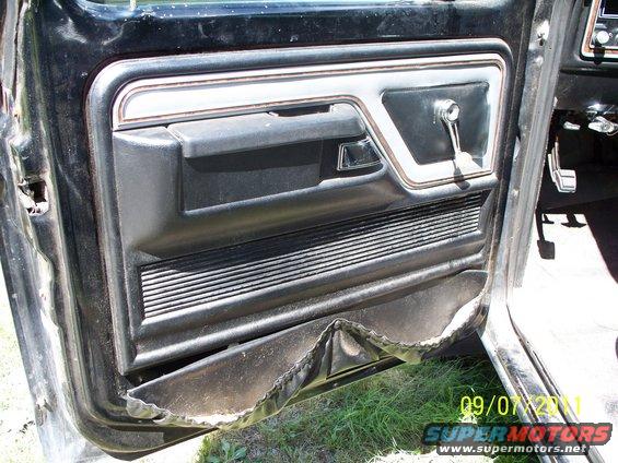 Interior door panel with chrome trim and manual window crank