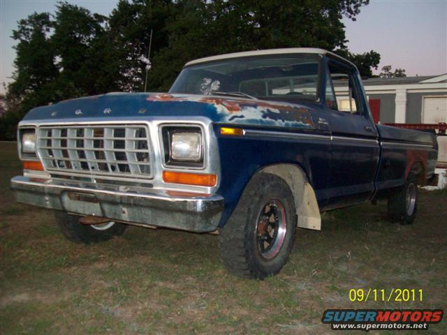 Blue 1979 Ford F-150 pickup truck with a white roof, parked outside on grass