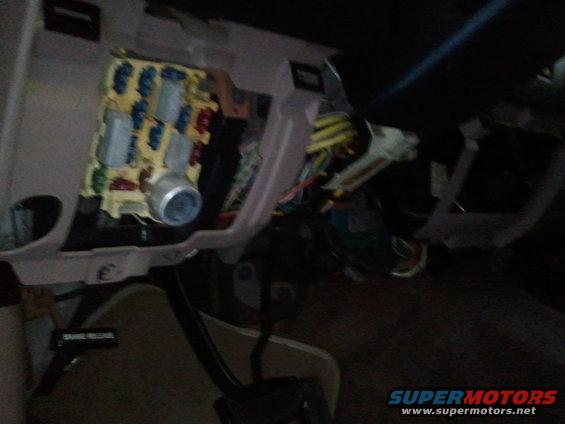 Fuse box and wiring under dashboard. Some fuses are blue, red, and gray