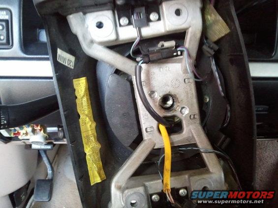 1994 Ford Bronco steering column assembly with yellow warning sticker and exposed wires