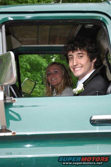guy in suit and girl in gray top in a green 1970s truck