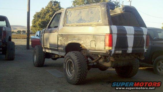 Gray Ford Bronco with black and white striped tailgate, lifted suspension, and off-road tires