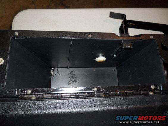 Black glove box interior with a light and visible hinges