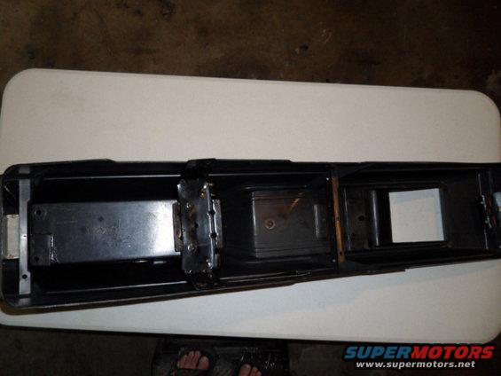Black car part with metal brackets and compartments