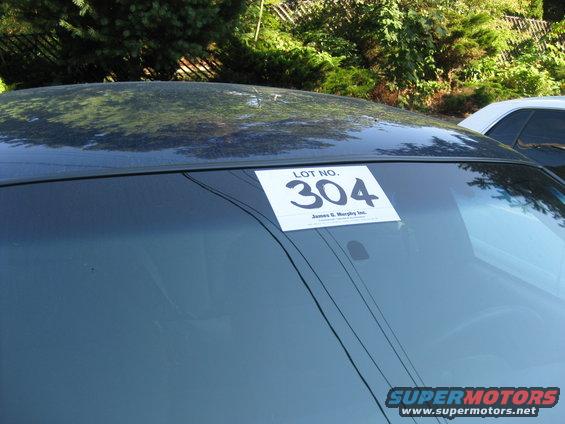 Car windshield with a "LOT NO. 304" sticker and "James G. Murphy Inc." text below it. Another car is visible to the right