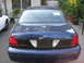 2003 Ford Crown Victoria - The rear of a Ford Crown Victoria Police Interceptor is shown, with a white vehicle partially visible to the left.