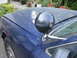 2003 Ford Crown Victoria - A blue 2003 Ford Crown Victoria is shown from the front passenger side, with a spotlight attached to the fender.