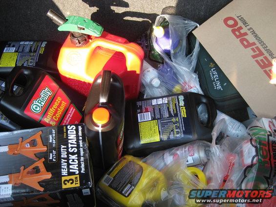 Car trunk with antifreeze, oil, jack stands, and other car maintenance items