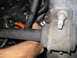 2003 Ford Crown Victoria - Close-up view of an engine component with a hand reaching into the engine bay.