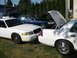 2003 Ford Crown Victoria - Three Ford Crown Victorias are parked outside, with two of them having their hoods open.