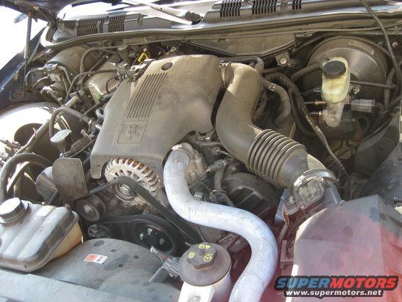 Engine bay with air intake, alternator, and brake fluid reservoir visible