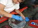 2003 Ford Crown Victoria - A person is cleaning a vehicle part, likely a differential cover, with a rag while wearing blue gloves.