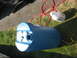 2003 Ford Crown Victoria - A blue barrel, a red hose, a white jug, and a yellow hose are laid out on grass and asphalt.