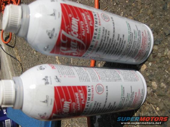 Two cans of Sea Foam motor treatment sitting on the ground