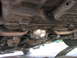 2003 Ford Crown Victoria - The underside of a vehicle is shown, focusing on the rear differential and exhaust components.