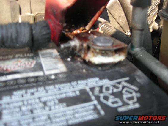 Corroded battery terminal with red protective cover