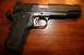 2007 Nissan Titan - A close-up view of a Springfield Armory pistol with textured grips and a silver trigger.
