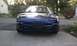 1994 Ford Probe - Front view of a blue Ford Probe parked on a concrete driveway with houses and trees in the background.
