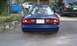 1994 Ford Probe - The rear of a blue Ford Probe is shown, with a white car and green van in the background.
