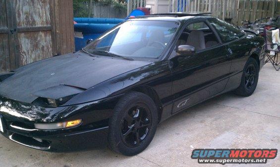 Black 1994 Ford Probe GT coupe with pop-up headlights and black wheels
