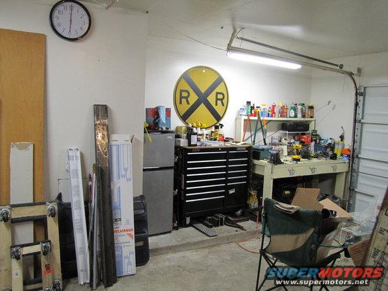 Garage interior with tool chest, workbench, and railroad crossing sign
