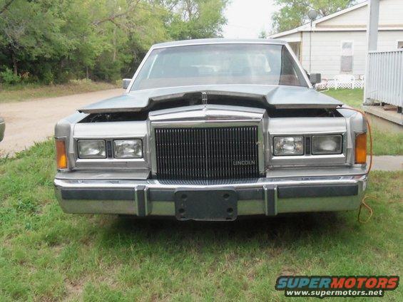 Front view of a silver Lincoln Town Car with hood open and "LINCOLN" text on grille