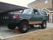 1989 Ford Bronco - 1989 Ford Bronco on jack stands, showing its lifted suspension and off-road tires.