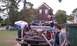 1979 Ford Bronco - People are loading wood debris into the bed of a pickup truck next to a dumpster.
