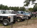 1979 Ford Bronco - Several Ford Broncos and F-Series trucks are lined up, including a brown and yellow 1979 Bronco.
