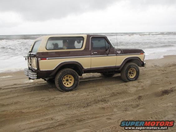 1979 Ford Bronco on beach, brown and tan two-tone paint, spare tire on rear