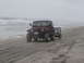 1979 Ford Bronco - Jeep Wrangler towing a trailer on the beach with the ocean nearby.