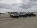 1979 Ford Bronco - Several 4x4 trucks and a Bronco are parked on the sand dunes on an overcast day.