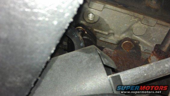 Close-up of engine part with hose and rust
