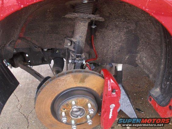 Red Brembo brake caliper and rotor on a vehicle