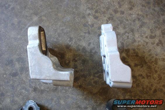 Two metal engine mounts on a concrete surface