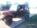 1989 Ford Bronco - A black Jeep Wrangler with flame graphics is parked next to a lifted truck.