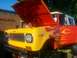 1989 Ford Bronco - This custom SUV features a vibrant flame paint job and its hood is open, revealing a stuffed toy.
