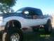 1989 Ford Bronco - Custom lifted pickup truck displays patriotic American flag graphics along its side.