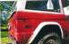 1974 Ford Bronco - Close-up of the rear passenger side of a red Ford Bronco with a white hardtop.