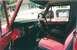 1974 Ford Bronco - Interior view of a red 1974 Ford Bronco, showing the dashboard and seats.