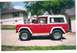 1974 Ford Bronco - Side view of a red 1974 Ford Bronco, a white hardtop and roof rack.