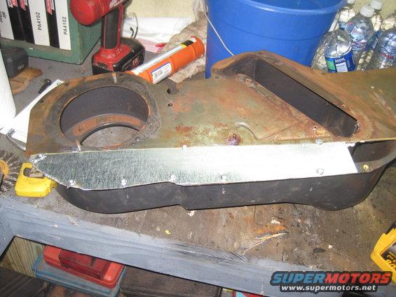 Rusted HVAC ducting with a metal patch, on a workbench