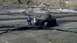 1986 Ford Bronco - A yellow off-road vehicle is stuck in thick mud with two people observing the situation.